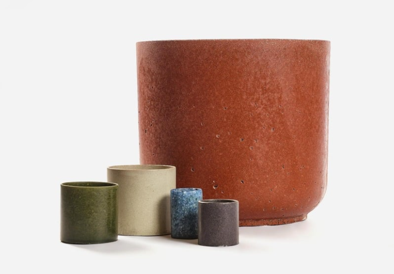 Échantillons de matières : composites recyclés vert olive, béton clair, verre bleuté, coquilles sombres et brique.